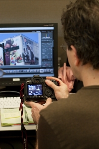 one person looking at a camera and a computer